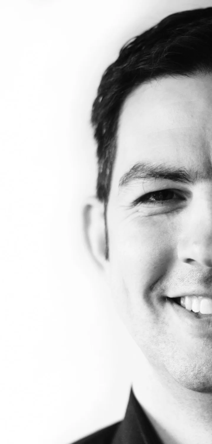 Portrait of Michael Hengherr, smiling, half of his face cropped at the right edge of the page
